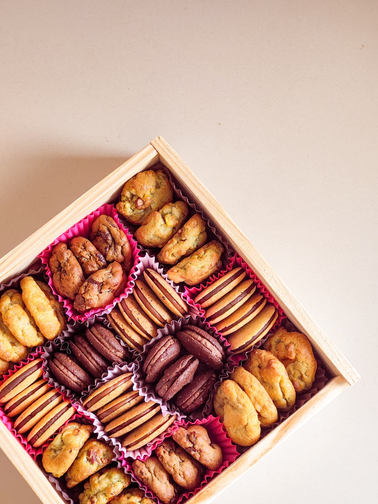 Detalhe da caixa Deli Delicadezas aberta, com biscoitos e doces em forminhas
